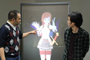 特製の等身大タッチパネルでキャラクターを動かす中城氏（左）。夢は『Live2D』を活用したアニメ映画でのアカデミー賞獲得と大きい