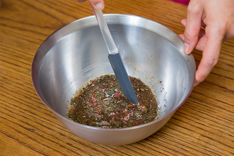 ④　次にソースを作っていきます。まずは種を取った梅肉を包丁で叩き、しそはみじん切りにします。それからボールに梅肉、しそ、黒ごま、にんにく、その他調味料を入れてよく混ぜます。