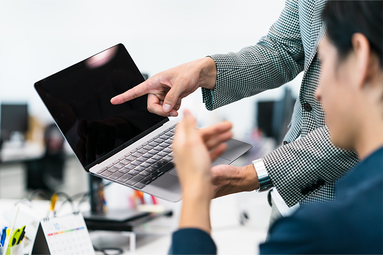 PCの画面を開いて指示をするイメージ