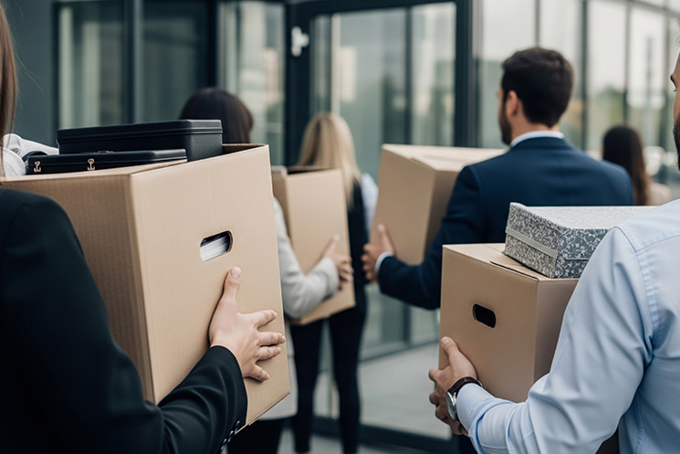 米マイクロソフトのレイオフで行われた5分間の非対面会議を象徴するイメージ画像。私物をまとめオフィスを去る人々と、Teamsの『極めて重要なアップデート』という通知から始まった突然の解雇宣告のリアリティ