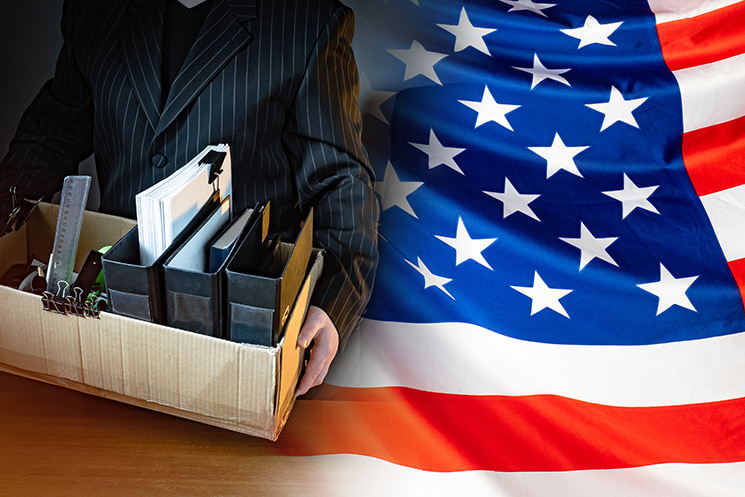 星条旗を背景に、荷物をまとめて職場を去るビジネスパーソンのイメージ。かつての『のんびり働けるビッグテック』が消滅し、シニア層にまで『昇進できなければ退職』を迫る『Up or Out』の圧力が強まる米国の厳しい雇用実