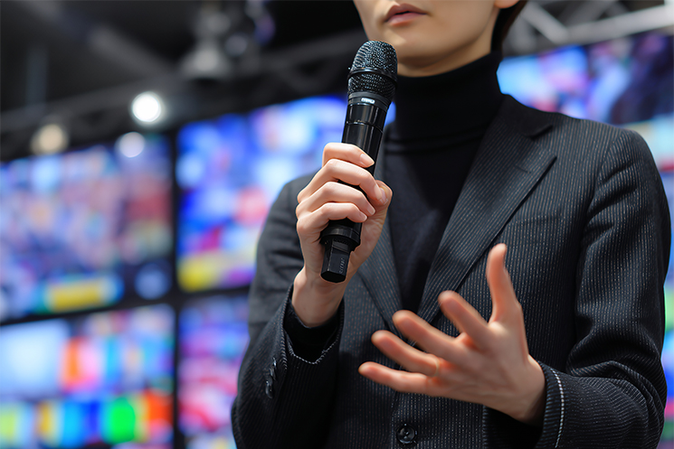 男性エンジニアがテックカンファレンスに登壇しスピーチを行っている様子