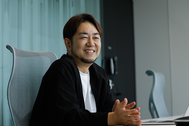 MIXIのフェローに就任した竹野太一さん。オフィスにて、AIがもたらすインパクトや個人と企業の境界線が曖昧になるIPビジネスの現状について語る様子