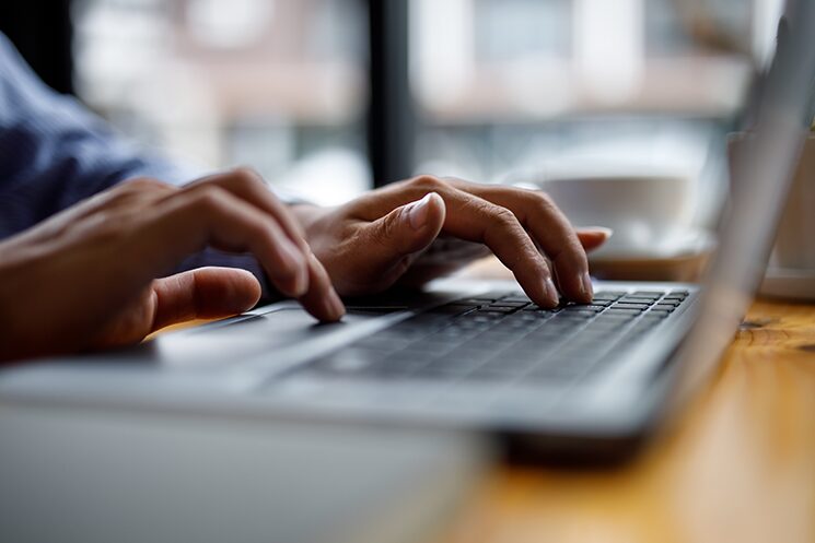 チャットに部下へのフィードバックを打ち込んでいる手元のイメージ写真