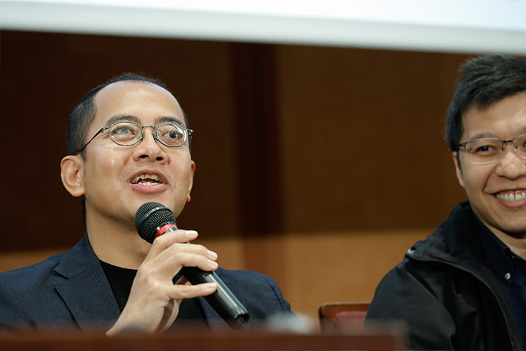 暦本純一教授の最終講義にて、教授がこれまでに撒いてきた研究の布石が形作った「未来の一部」の中に自分たちはいると語り、大学の枠を超えてさらに境界を無くしていく教授の今後の活動への期待を、右隣で満面の笑みを浮かべるHuaweiの張鑫磊氏と共にマイクを手に活き活きと語る、Preferred NetworksのAdiyan Mujibiya氏