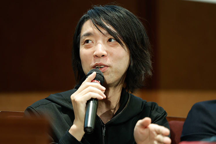 暦本純一教授の最終講義にて、実父である作家の落合信彦氏が亡くなった際にAIエージェントから自律的なお悔やみメッセージが届いたリアルな衝撃を語り、2000年代的な人間中心設計の限界と、人間の生老病死にすら独自の距離感で入り込むシステムとの共生について真摯に語る落合陽一氏