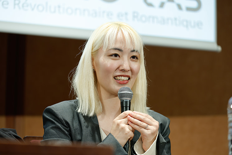 暦本純一教授の最終講義にて、文系学生だった2013年に東大のイベント「TEDxUTokyo」の裏方として教授に出会い、「10歳に戻れるスイッチを押して発想を転換する」という言葉に背中を押されてエンジニアの道を歩み始めた原点を、マイクを手に穏やかな笑顔で語る、GoogleでChrome開発に携わる西條柚氏
