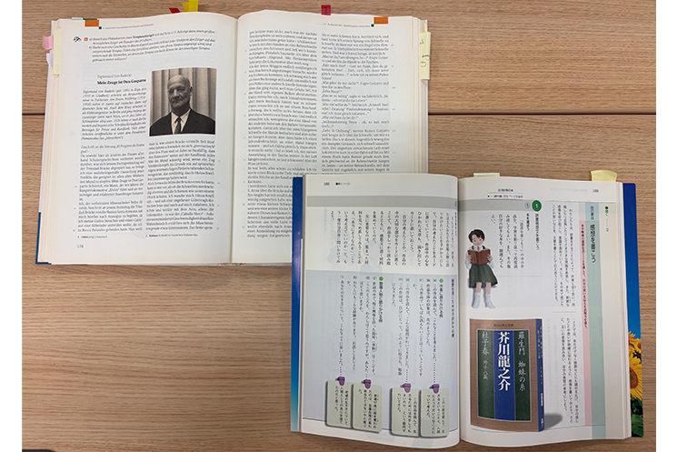 ドイツ（左上）と日本（右下）の中学1年生の国語教科書の比較。日本の教科書が情緒的なイラストや親しみやすさを重視しているのに対し、ドイツの母語教育教科書は文字が詰まった短編小説や作文の設計図が並び、幼少期から「論理的に言葉を運用する技術」を日常的に叩き込む仕組みの違いを視覚的に示している