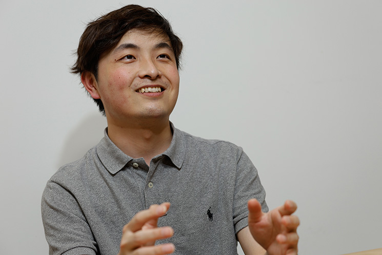 笑顔で身振り手振りを用いて語るアクストリア株式会社の小林勇輝さん。営業と連携した希望通りの案件アサイン体制や、SESプロジェクトでの成長環境について語っている様子
