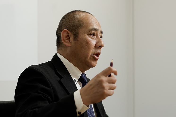 ペンを手に真剣な表情で語るインフォース代表取締役の濱松毅氏。ライセンス販売を軸とするマイクロソフトに対し、実際の現場構築を行える自社の強みを示すとともに、顧客と直接つながることでAccessからのクラウド化やBI、AI活用へと展開する独自のビジネスモデルについて解説する一幕