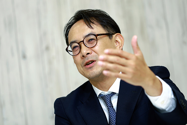 眼鏡を掛けた前LINEヤフー代表取締役会長の川邊健太郎氏が、手を広げながら生き生きとした表情で身振り手振りを交えて語るポートレート。推し活での体験談を引き合いに出し、合理性やデータ分析を重視するAI時代だからこそ、人間は頭脳だけに頼らず「ヒュー！」と歓声を上げるような喜怒哀楽や感情、五感を前面に出して振る舞うこと（人間ドリブン）の重要性を説く文脈に配置されている