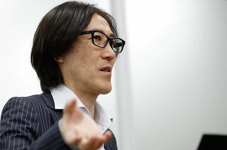 ネットワークの『つなぐ』発想に対し、必要な通信のみを許可し『誰がどの情報にどこまでアクセスできるか』を制御するセキュリティ特有の思考プロセスについて、真剣な表情で熱弁を振るう小原氏。給与システムなどを例に、情報漏えいを防ぐためのアクセス権限設計の重要性を説く様子